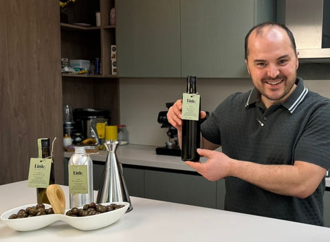 herman pobrati in his kitchen with little olive oil bottles