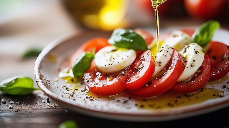 capresse salad with little olive oil evoo being poured over