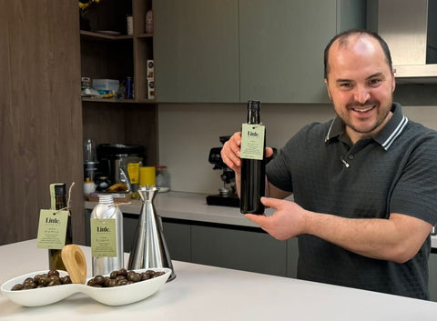 herman pobrati in his kitchen with little olive oil bottles